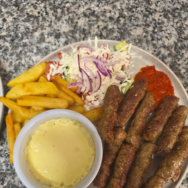 Cevapcici mit Pommes, Shopska Salat, Ajvar und Kajmak